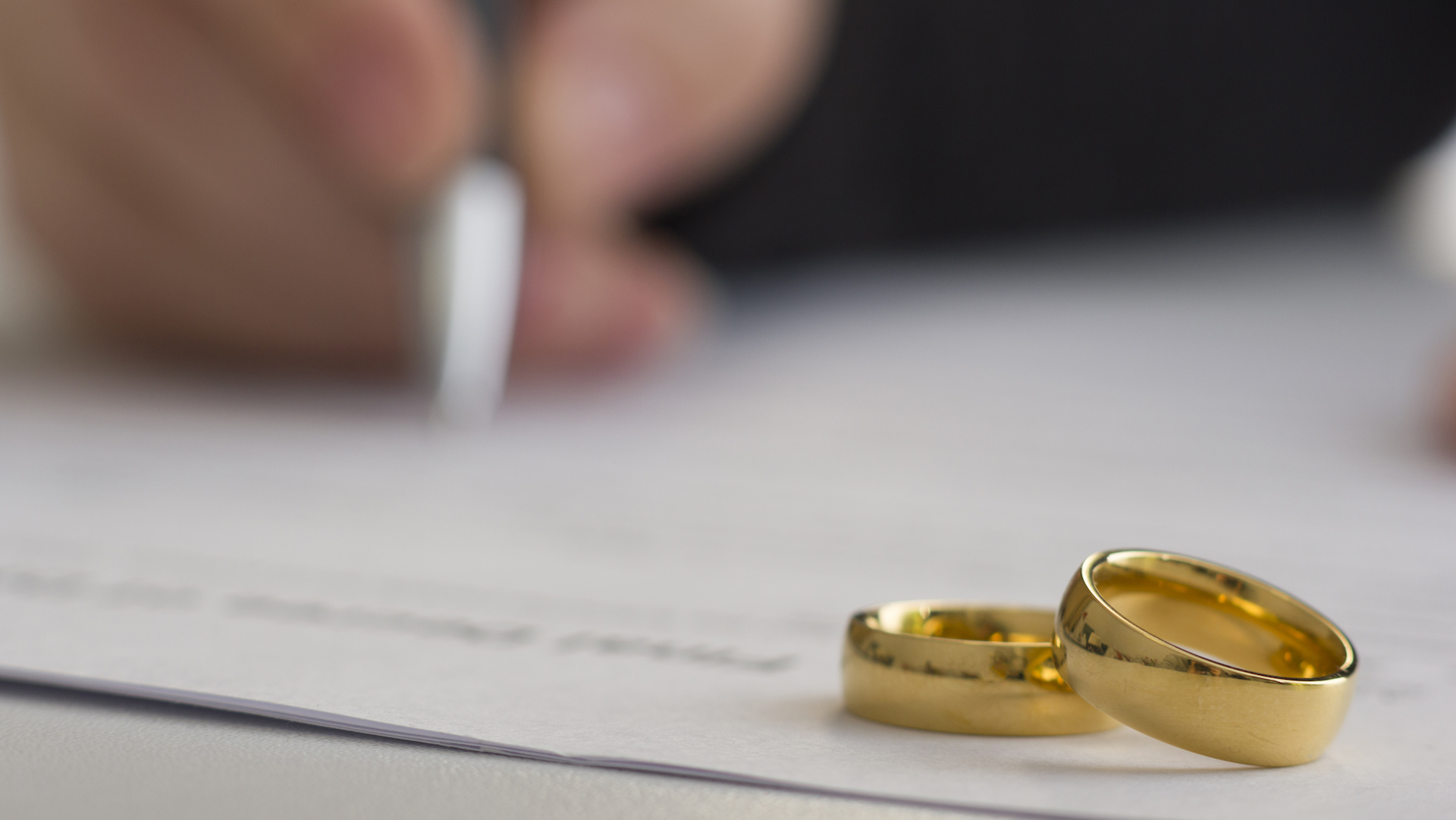 Hands Of Wife, Husband Signing Decree Of Divorce, Dissolution, Canceling Marriage, Legal Separation Documents, Filing Divorce Papers Or Premarital Agreement Prepared By Lawyer. Wedding Ring